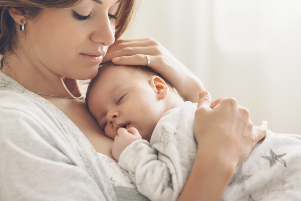 Mother holding a sleeping newborn